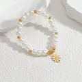 Dettaglio del bracciale con ciondolo a margherita, perle bianche e sfere dorate su sfondo - 单雏菊串珠B款(S-B1094-si)