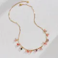 Detail van gekleurde kralen en kwastjes op een goudkleurige roestvrijstalen ketting - Gekleurde Kralen Stijl (S-N2159)