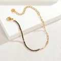 Détail du bracelet en acier inoxydable doré avec zircon noir et chaîne trombone - Noir