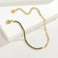 Vue détaillée de la chaîne à trombones dorée jointe au bracelet de tennis en zircon vert - Vert