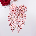 Détail d'un grand nœud à cheveux blanc avec motifs de cœurs rouges et texte LOVE imprimé - Base Blanche LOVE