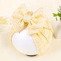 Detail of light yellow baby hat with large bow and wavy ribbed knit texture - Yellow (Ribbed)