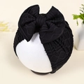 Detailed close-up of black newborn turban hat featuring a large bow and textured knit fabric - Black (Ribbed)