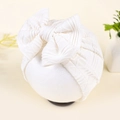 Detail of white newborn baby hat featuring jacquard waffle texture and large soft bow - White (Ribbed)