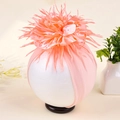 Detailaufnahme eines rosa Baby-Stirnbands mit einer großen, gefiederten Paillettenblume - Blassgrün