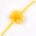 Dettaglio di un fiore di chiffon giallo brillante su una fascia elastica per neonati - Giallo