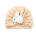 Beige knitted baby turban hat featuring a cute white plush bunny doll decoration - Cream