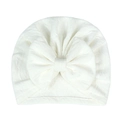 Detailed view of white newborn baby hat with large soft bow and elastic knit texture - White