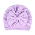 Makro-Detail des Lavendel-Babymütze mit feiner Strickstruktur und großer Zierschleife - Lila
