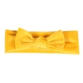 Detailed close-up of bright yellow corduroy baby headband with large bow decoration - Yellow