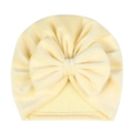 Detail der Baby-Turban-Mütze aus cremegelbem Rippstrick mit einer weichen Schleife - Gebrochenes Weiß