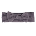 Gros plan d'un bandeau élastique violet foncé en tissu crépon doux avec un nœud papillon - Gris foncé