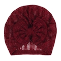 Dettaglio macro del cappello in pizzo rosso vino per neonati con fiore e trama traforata - Borgogna