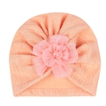 Detail eines korallenrosa Baby-Turban-Hutes mit großer 3D-Tüllblume und Plissee-Struktur - Blassgrün