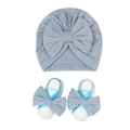 Detailed view of fog blue knitted baby hat and matching bow sandals on white background - Blue