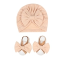 Detail view of pink knitted baby turban hat and matching bow sandals set on white background - Light Coffee