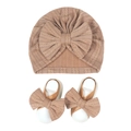 Macro view of neutral beige waffle knit baby turban hat and matching bow sandals set - Tan