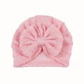 Detail van roze gebreide babytulband met holle textuur en decoratie van een strikknoop - Roze