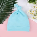 Flat lay view of a light blue knotted baby beanie on a clean decorative background - One Size / Lake Blue