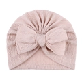 Détail du bonnet en tricot rose pour bébé avec motif torsadé et grand nœud décoratif - Café Clair