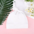 Vista detallada de un gorro de algodón blanco para recién nacido con nudo y borde doblado - Talla única / Blanco