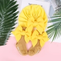Vista piatta del turbante giallo per neonati con fiocco e calze abbinate su sfondo bicolore - Taglia unica / Giallo