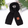 Detail of black chunky knit scarf featuring a brown leather label with EST MOVE engraving - Black