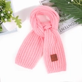 Close-up of pink chunky knit scarf with premium leather tag and soft wool texture - Pink