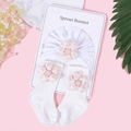 Détail d'un ensemble bonnet et chaussettes bébé blanc avec fleurs à pois roses - Fleur à Pois Blanche