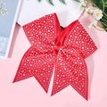 Close-up of red cheer bow hair tie with sparkling rhinestones on a pink background - Red
