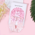 Detail von rosa Baumwoll-Babyturban und Socken mit 3D-gepunkteten Blumendekorationen - Rosa Punktmuster Blume