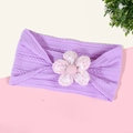 Détail macro du bandeau tricoté lavande pour bébé avec décoration de fleur à paillettes - Violet