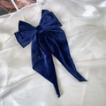 Detalle de un lazo de terciopelo azul oscuro con textura suave y cintas largas - Azul marino