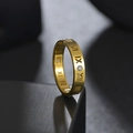 Macro shot of gold titanium ring featuring hollow Roman numerals and inlaid zircon stones - Gold