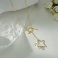 Elegante collana a Y dorata con ciondoli a stella scavati e dettagli in perle bianche - Oro