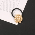 Dettaglio ravvicinato di un elastico per capelli ad alta elasticità con fiori dorati e perle - Oro