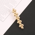 Detailed view of the layered gold metal beads on a sleek minimalist fashion hair clip - Gold