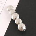 Zilveren metalen haarklem met cirkelvormige textuur op een minimalistische achtergrond - Geborstelde schijfstijl / Zilver