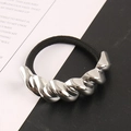 Detailansicht eines silbernen Metallornaments an einem elastischen schwarzen Haargummi - Silber