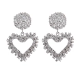 Silver hollow heart drop earrings with textured hammered finish on white background - Silver