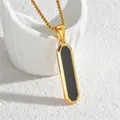 Detailed macro view of a polished gold geometric pendant with black inlay on a box chain - Beveled Gold