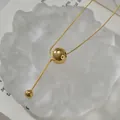 Detalle de un collar de cadena de serpiente dorada con colgante de bola de metal - Dorado