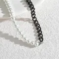 Detail der minimalistischen Halskette mit weißen Perlen und klobiger schwarzer Edelstahlkette - Schwarz