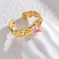 Detailed close-up of a gold braided open ring featuring a rectangular pink zircon stone - Pink Rectangular Gemstone Style (S-R701-cfx)