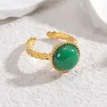 Detalle de anillo ajustable dorado vintage con gema verde y textura martillada única - Verde
