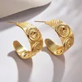 Close-up of golden C-shaped earrings with sunburst relief and bohemian texture detail - Sunburst Vintage Style (S-E587)