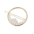 Dettaglio del fermaglio circolare dorato con perle bianche disposte lungo l'anello - Oro