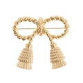Élégante broche nœud doré avec texture torsadée et pendentifs glands sur fond blanc - Doré