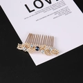 Dettaglio di un pettine per capelli vintage dorato con gemma blu e cristalli bianchi - Zircone Bianco