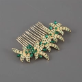 Detailed view of elegant gold floral hair comb with green rhinestones on dark background - Green Rhinestone Style